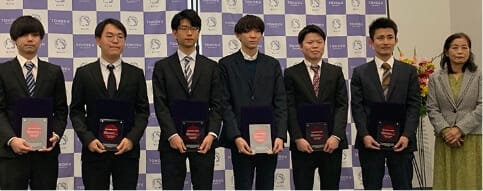 ベストポスター賞授賞式集合写真(サイエンスキャンパスホール)小谷元子 理事、シンポジウム大会長(右)と参加した受賞者たち